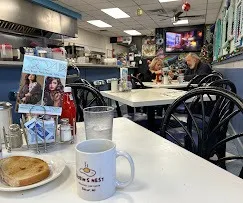 Inside Robin's Nest Belmar with a branded coffee mug and toast